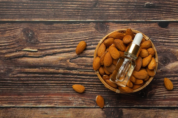 Aceite de almendras en botella sobre fondo de madera oscura.