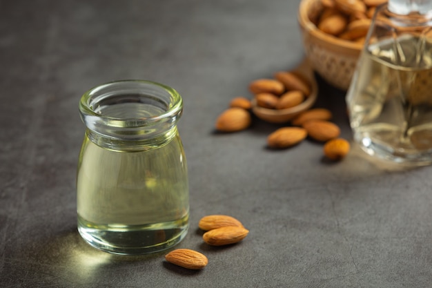 Aceite de almendras en botella sobre fondo oscuro