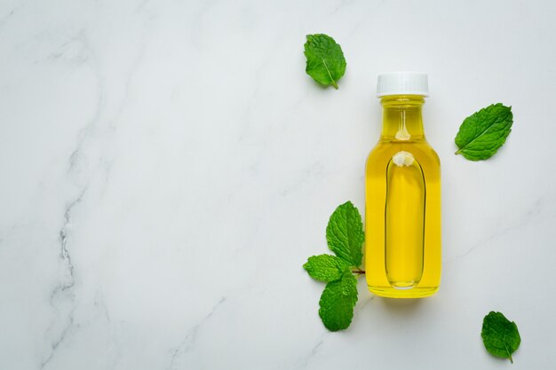 Aceite esencial de menta en botella con menta verde fresca