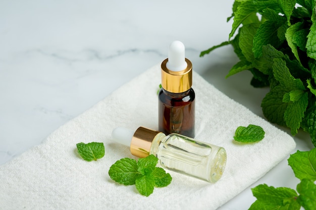 Aceite esencial de menta en botella con menta verde fresca