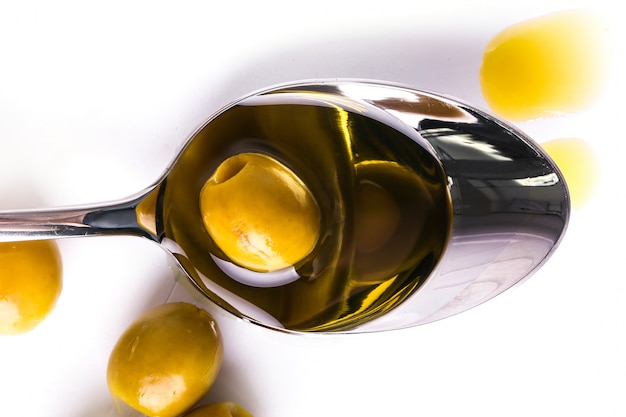 Aceite de oliva en cuchara y aceituna
