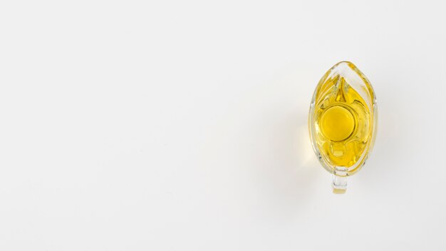 Aceite de oliva minimalista en un vaso con fondo blanco copia espacio