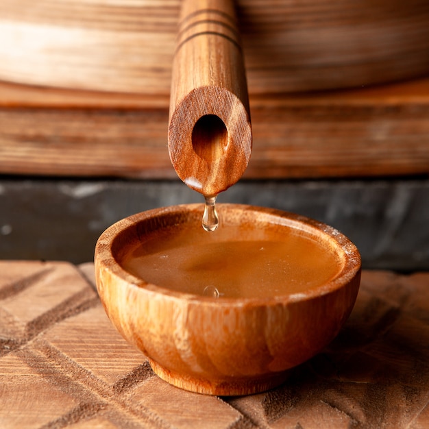Foto gratuita aceite que fluye en un tazón de madera