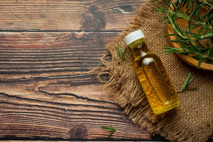 Foto gratuito aceite de romero en botella con plantas de romero