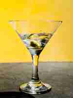 Foto gratuita aceituna verde chapoteando en martini