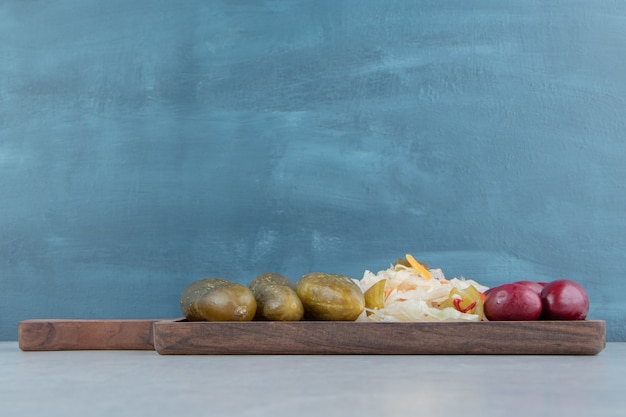 Foto gratuita aceitunas en escabeche, repollo y pepino en una tabla