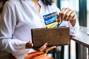 Foto gratuita aceptar tarjetas de crédito de una cartera marrón para pagar los bienes