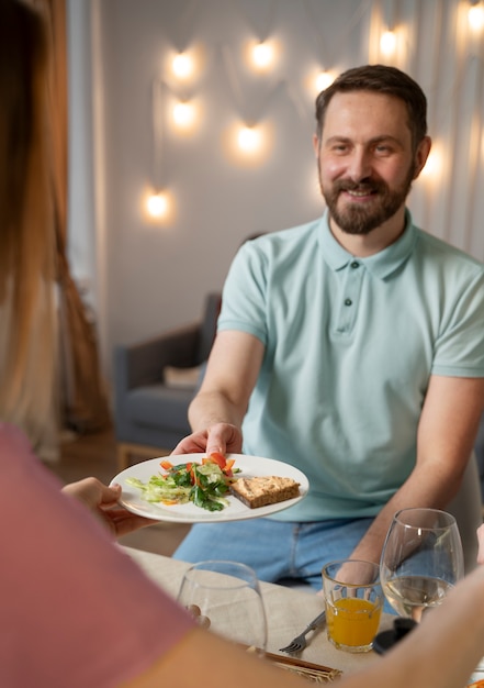 Acercamiento a un adulto joven en una cena con amigos