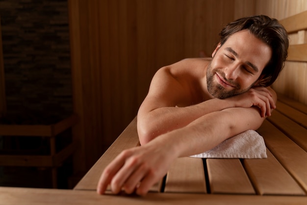 Acercamiento al hombre relajándose en la sauna