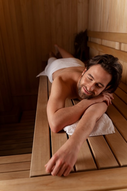 Acercamiento al hombre relajándose en la sauna