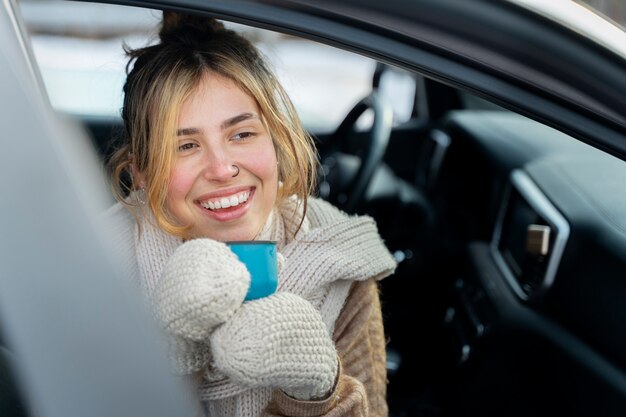 Foto gratuita acercamiento a una mujer disfrutando de una bebida caliente durante un viaje de invierno