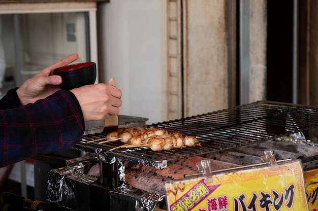 Foto gratuita acercamiento a la persona que cocina comida callejera japonesa