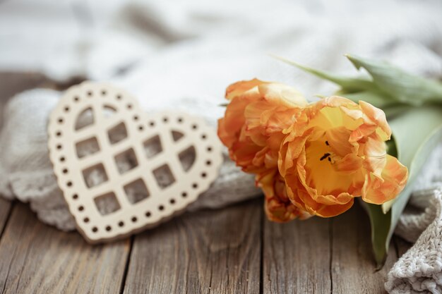 Acogedor bodegón con un corazón decorativo y un ramo de flores de cerca