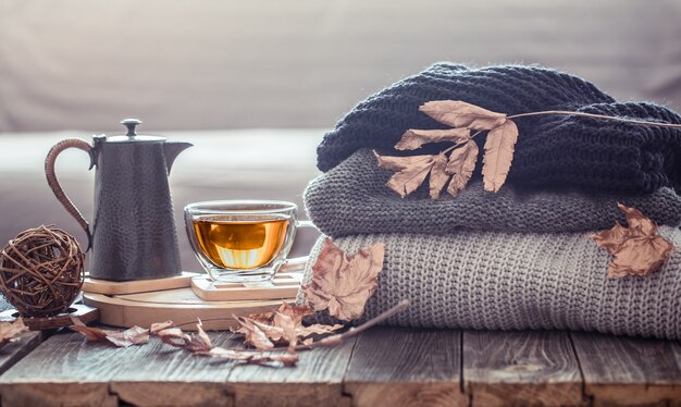 Acogedor bodegón otoñal con una taza de té y elementos de decoración en la sala de estar. Concepto de confort en el hogar