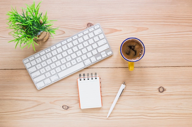 Foto gratuita acogedor lugar de trabajo con teclado de café y portátil