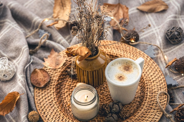 Acogedora composición casera con una taza de café, una vela y detalles decorativos.