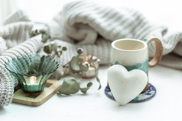 Acogedora composición casera con taza y corazón decorativo.