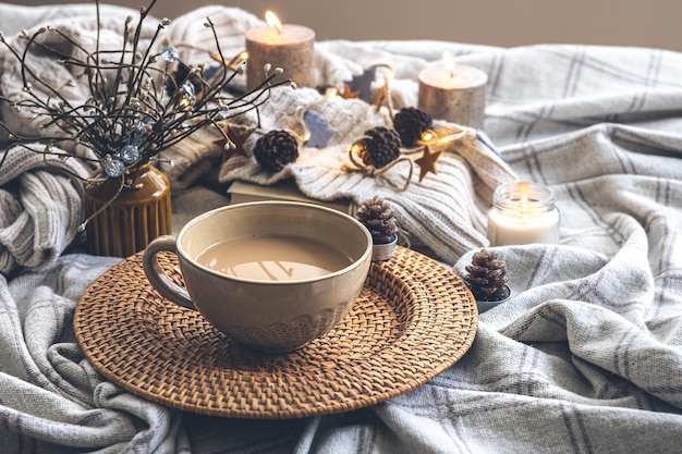 Acogedora composición otoñal con una gran taza de café en la cama