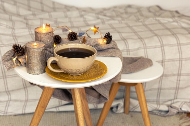 Acogedora composición otoñal con una taza de té y detalles decorativos