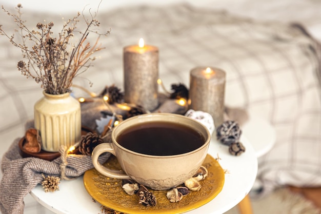Acogedora composición otoñal con una taza de té y detalles decorativos