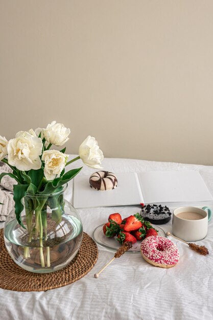 Acogedora composición con un ramo de tulipanes y una taza de café.