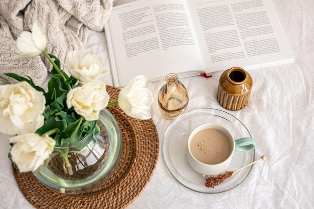 Acogedora composición con un ramo de tulipanes y una taza de café.