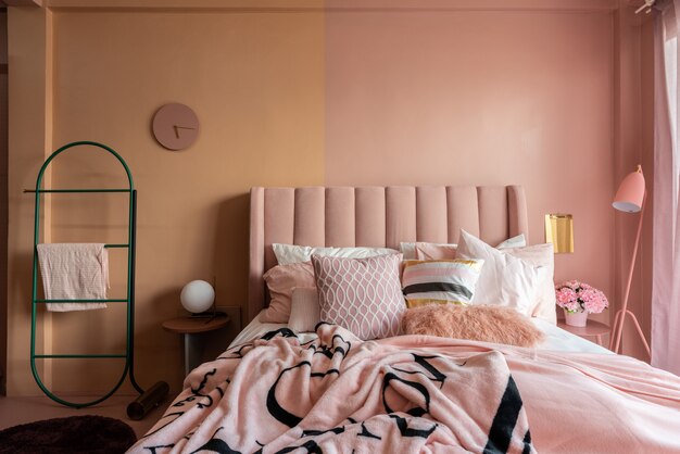 Acogedora esquina de dormitorio rosa con cama de tela de terciopelo