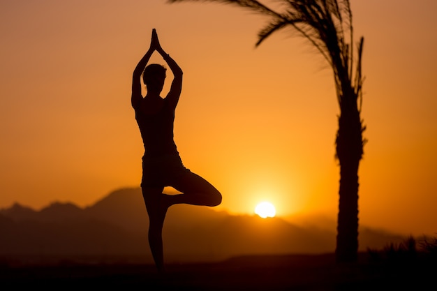 Actitud del árbol del yoga en la localización tropical