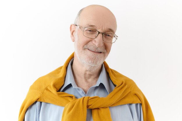 Actitudes, sentimientos y emociones humanas positivas. Imagen de hombre jubilado atractivo feliz con barba blanca y cabeza calva expresando alegría y placer, mirando a la cámara con una alegre sonrisa amistosa