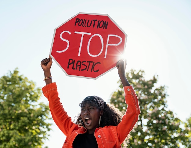 Activista de mujer sosteniendo la señal de stop tiro medio