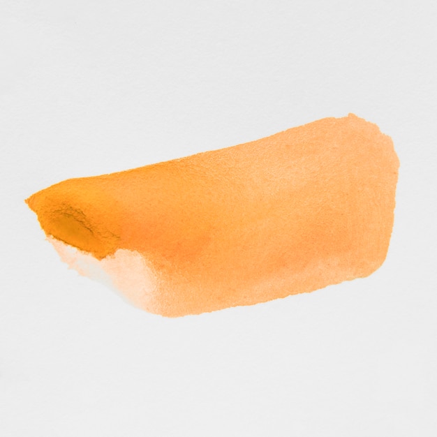 Una acuarela naranja teñida sobre lienzo de papel blanco.
