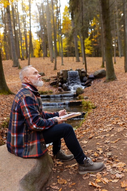 Foto gratuita acuarelista pintando al aire libre en el bosque