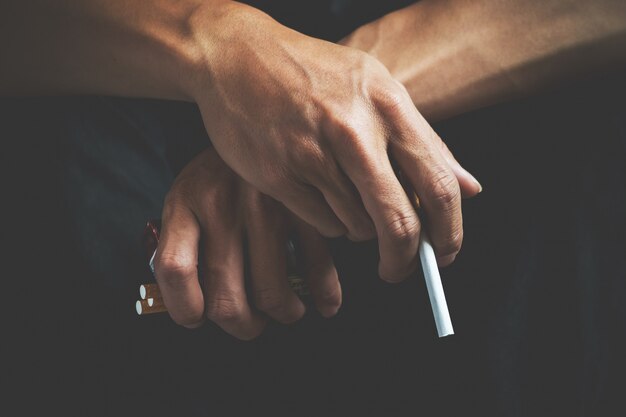 Adicción al cigarrillo. Humo de la nicotina del tabaco. Insalubre, peligro, malo, hábito narcótico. Filtro blanco. Riesgo para la salud, enfermedad del cáncer. Deje de suspender la droga tóxica. Concepto de estilo de vida. Paquete en la mano