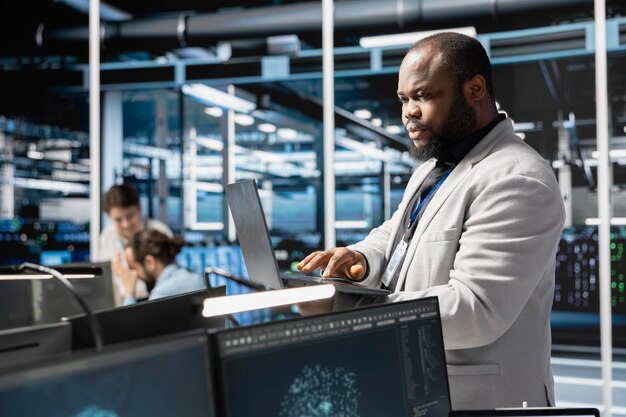 El administrador del centro de datos utiliza la computadora portátil para actualizar el equipo de configuración técnica de los servidores