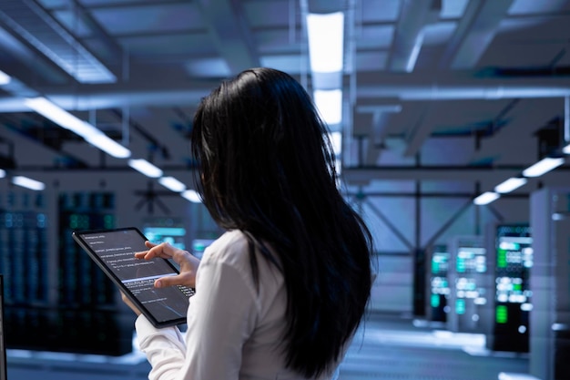 Administrador en el centro de datos utilizando la tableta para comprobar si hay problemas de rendimiento del servidor