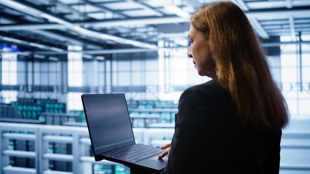 Administrador de sistemas en el centro de datos ejecutando utilidades de comprobación de errores en la computadora portátil