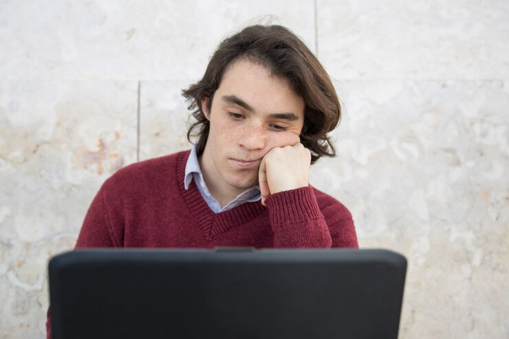 Foto gratuito adolescente aburrido usando una computadora portátil al aire libre
