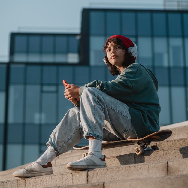 Adolescente al aire libre escuchando música con auriculares mientras usa el teléfono inteligente