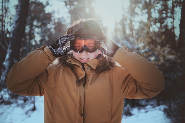 Foto gratuita un adolescente alegre disfruta de un paseo invernal en el bosque en un día brillante y soleado.