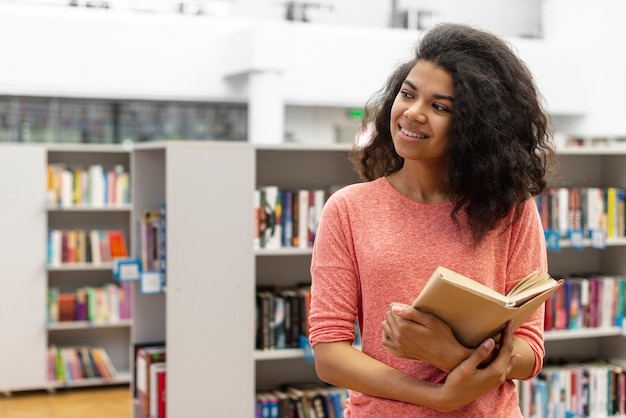 Adolescente de alto ángulo en la lectura de la biblioteca