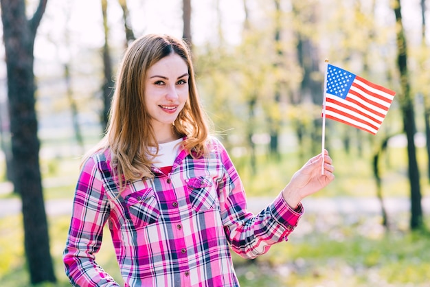 Adolescente con bandera de Estados Unidos en mano