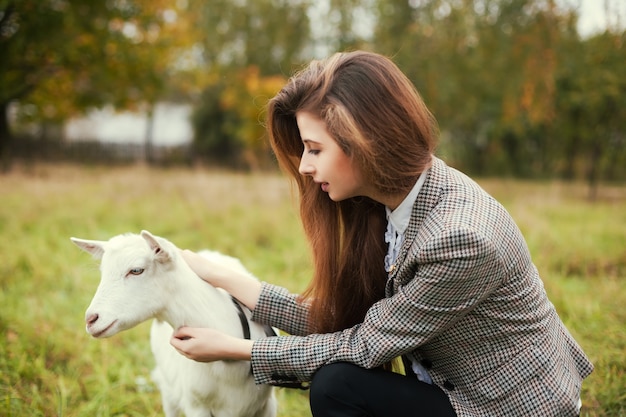 Adolescente con una cabra al aire libre