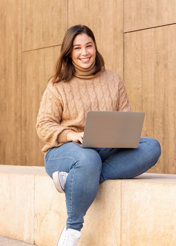 Foto gratuito adolescente casual sosteniendo su computadora portátil