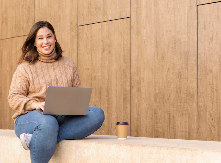 Foto gratuito adolescente casual sosteniendo su computadora portátil
