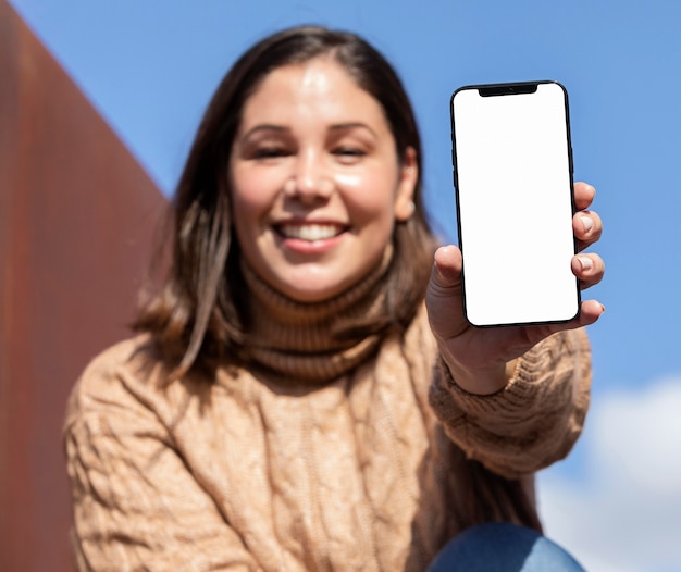 Foto gratuita adolescente casual sosteniendo su teléfono inteligente