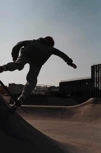 Foto gratuita adolescente divirtiéndose con patineta en el parque al aire libre