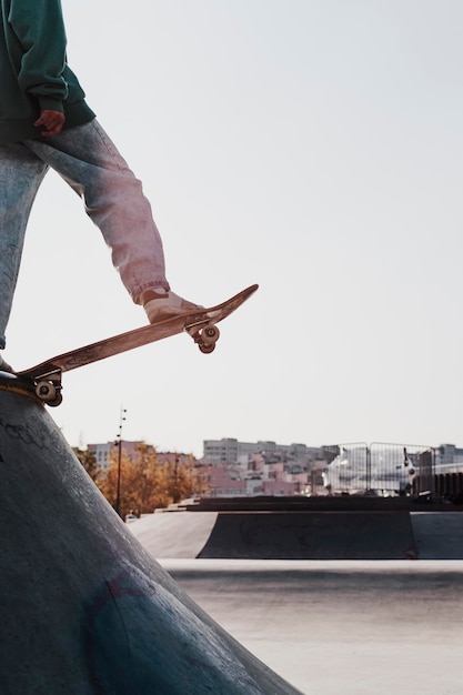 Adolescente divirtiéndose con patineta en el parque y copie el espacio