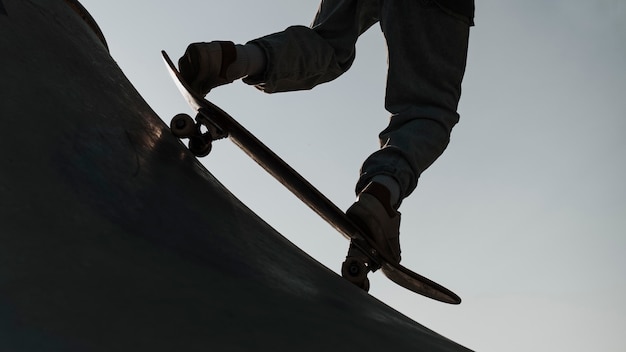 Adolescente divirtiéndose con patineta en la silueta del parque