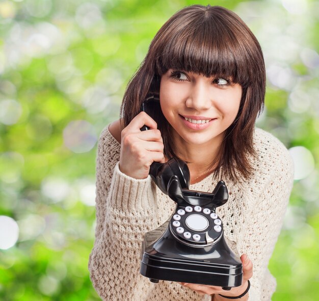 Adolescente emocionada utilizando un teléfono antiguo