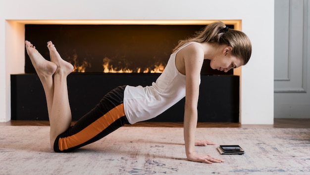 Foto gratuita adolescente entrenando en casa siguiendo instrucciones